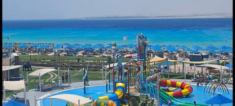 Beachfront water park with slides and loungers.