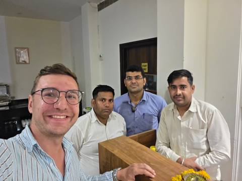 Group photo with four men indoors, posing near a counter.