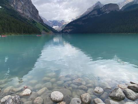       Calm lake surrounded by majestic mountains and lush forests.
  