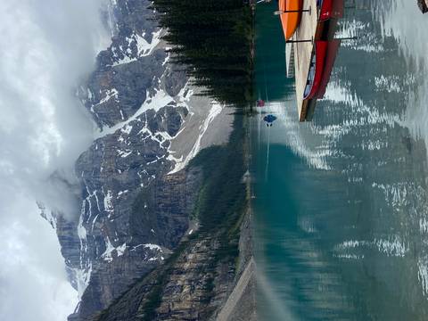       Lake with a dock and snow-covered peaks.
  