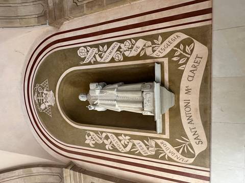 Statue inside a church niche, with inscriptions around it.
