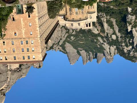       Historic monastery building nestled in a mountainous landscape.
  