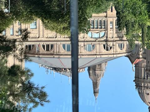      Taken from a moving vehicle, a glimpse of a large building with a domed roof.
  