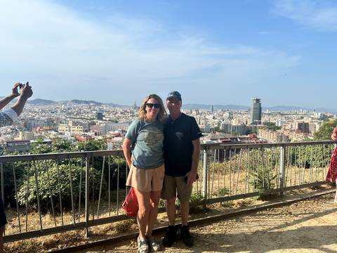      Couple posing with a panoramic view of a cityscape in the background.
  