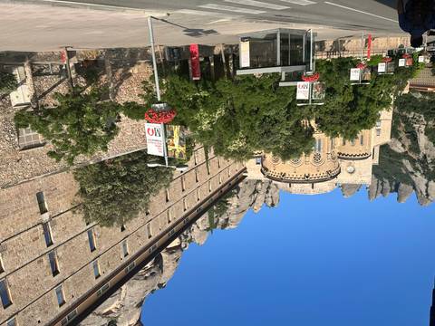 Monastery building with mountains in the background under a clear sky.