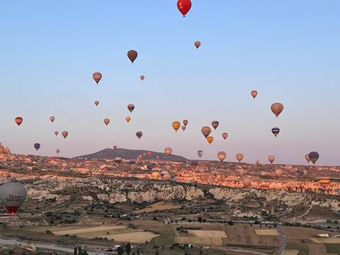 Hot air balloons over a rocky landscape.