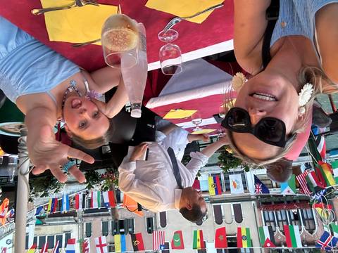       People dining at a restaurant by a canal.
  