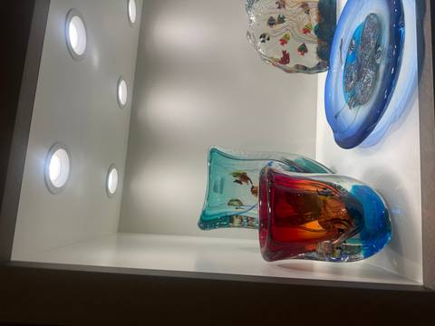 Vibrant glass sculptures displayed in a showcase.