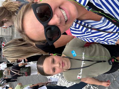       People amidst a crowd on a walkway.
  
