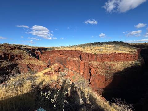 Deep red cliffs under a blue sky.