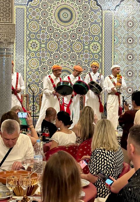       Musicians performing with traditional instruments indoors.
  