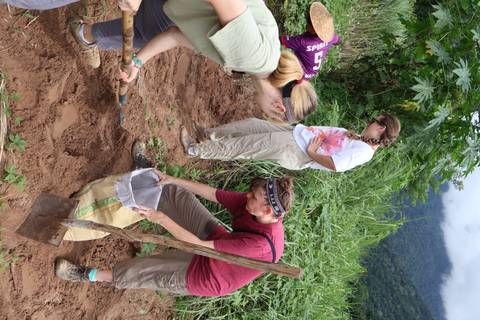 People engaged in soil work on a hillside.