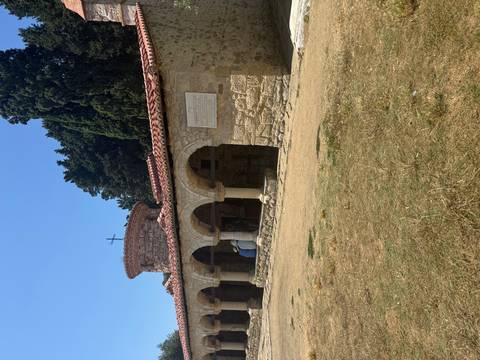 Historical stone building with arches and a tiled roof.