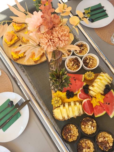 Buffet of tropical fruits and granola bowls on a table.