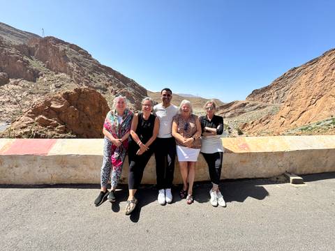 Group of people posing with scenic rocky hills in the background.