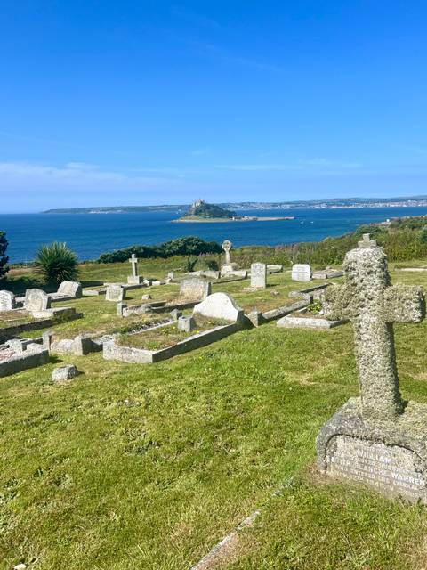 Graveyard with a scenic coastal view in the background.