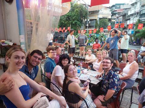 Group of people in an outdoor bustling street cafe, celebrating.
