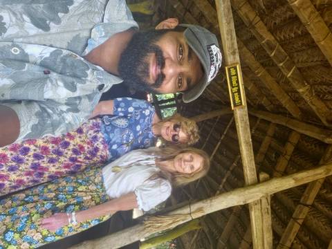 Selfie with three people in traditional attire inside a wooden structure.