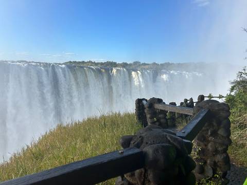 View of a large waterfall with mist and lush surroundings.