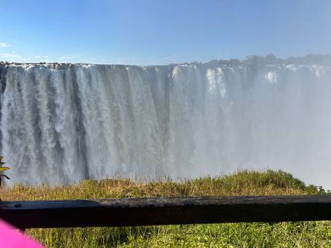 View of a large waterfall with mist and lush surroundings.