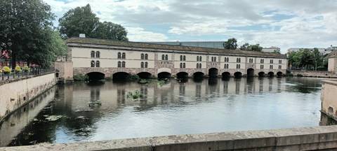 Covered bridge over a river with arches and reflections.