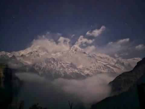Cloudy sky with Himalayan mountains partially visible.