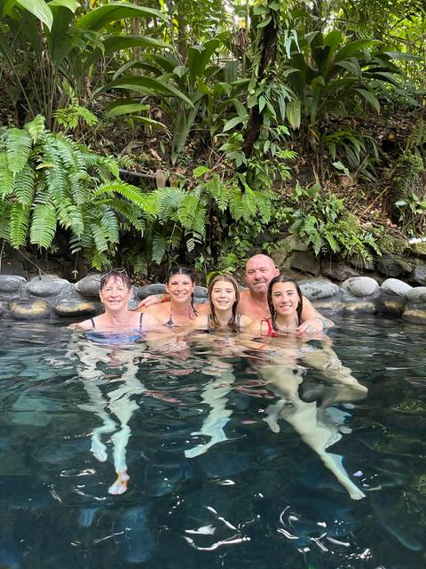 Family relaxing in a natural hot spring.