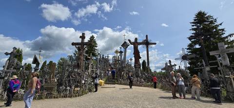 A site filled with numerous crosses and people visiting.
