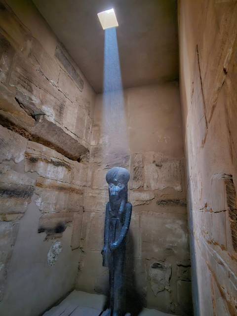 An ancient sculpture inside a stone chamber.