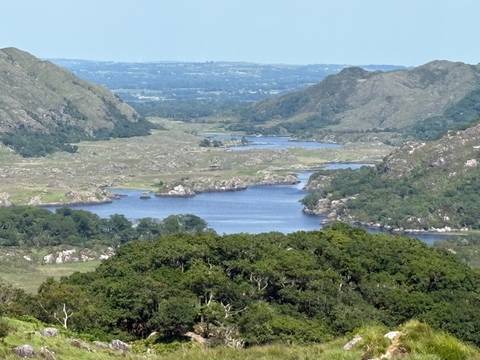 A scenic view of a lake surrounded by hills.