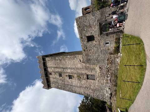 A large stone tower with clouds and blue sky.