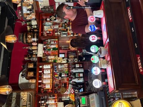 Interior of a traditional pub with various drinks displayed.