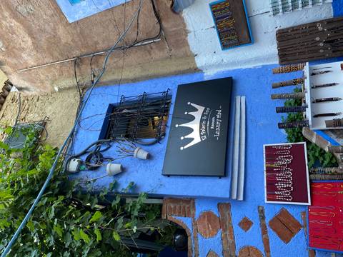 A blue wall with a shop sign and various displayed items.