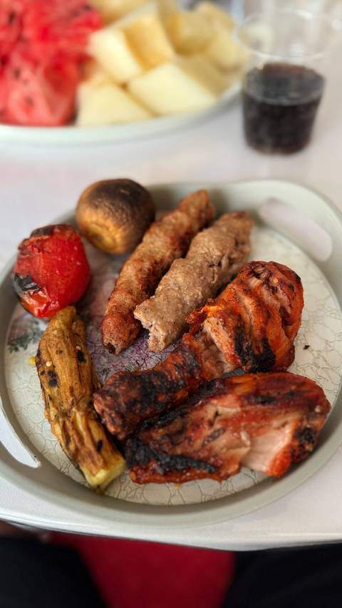       Plate of grilled meats and vegetables.
  