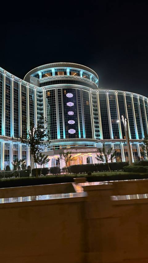 Modern glass building with decorative lights at night.
