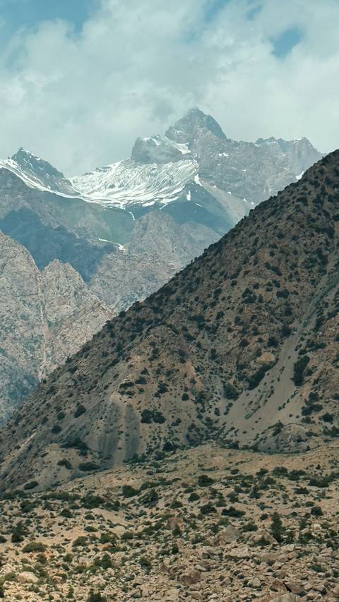Mountainous landscape with steep cliffs and sparse vegetation.