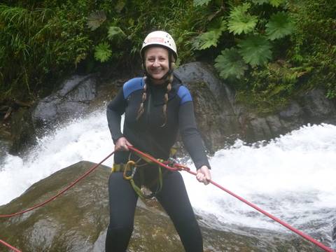       Woman rappelling near a waterfall.
  
