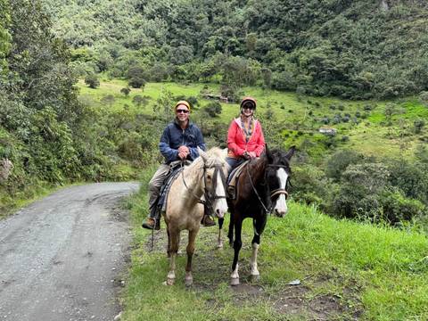       Two people horseback riding on a scenic trail.
  