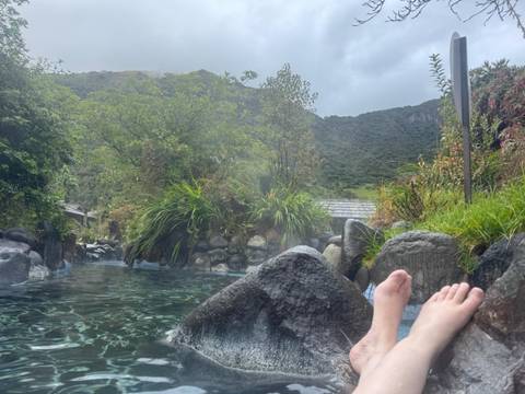       Person relaxing in a natural hot spring pool.
  