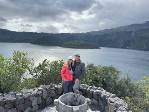       Couple posing with a scenic lake and mountains in the background.
  