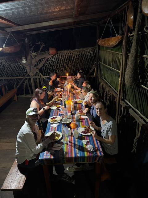       Group dining at a long table with traditional setup.
  