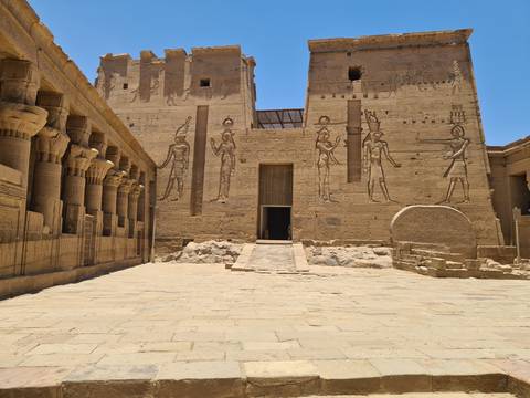 Ancient Egyptian temple with carvings and bright sunlight.