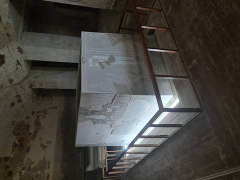 Ancient stone sarcophagus with intricate carvings inside a dim environment.