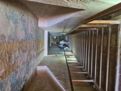 Tourists walking down a well-lit ancient staircase.