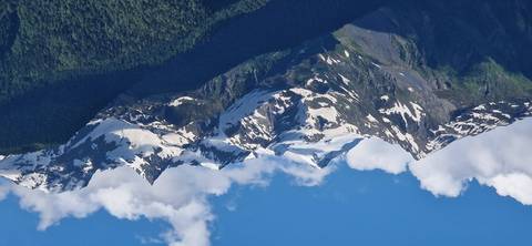 Snow-capped peaks of mountains under a clear blue sky.