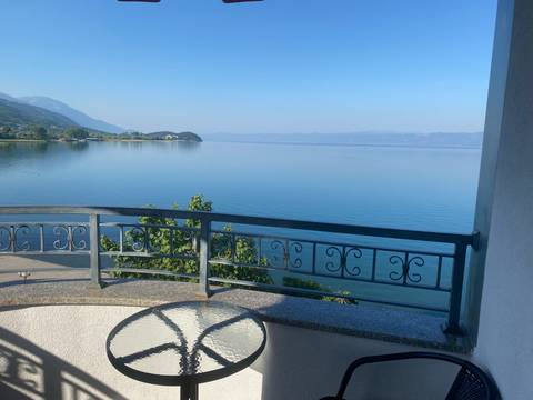 Lake view from a balcony with surrounding mountains.