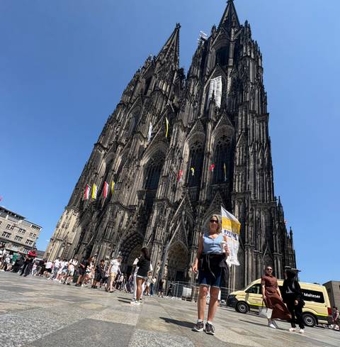 Large gothic cathedral with tourists in front.