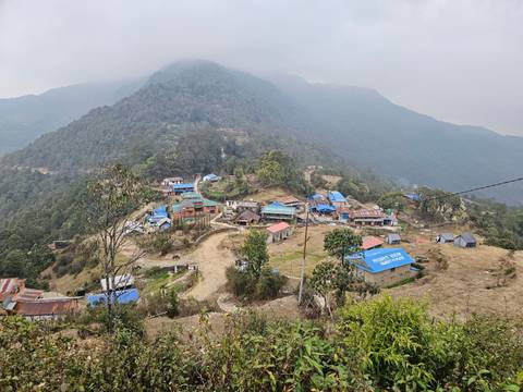 High-altitude village with colorful rooftops nestled in mountains.