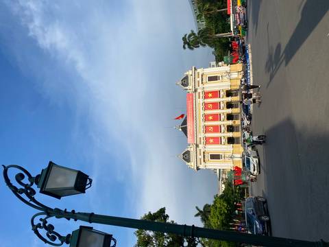       Historical building with flags and a busy city square.
  