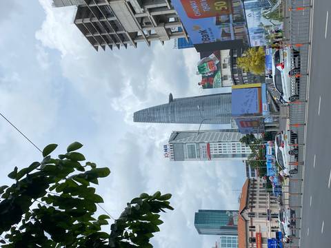       Tall modern skyscraper with clouds in the background.
  